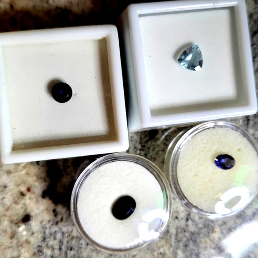 Four Loose faceted gemstones- aquamarine, sapphires, tanzanite